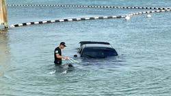 A Key West, FL, police officer helps salvage a black Dodge Challenger that was driven into the Atlantic Ocean off Simonton Beach by an allegedly impaired driver Sunday.