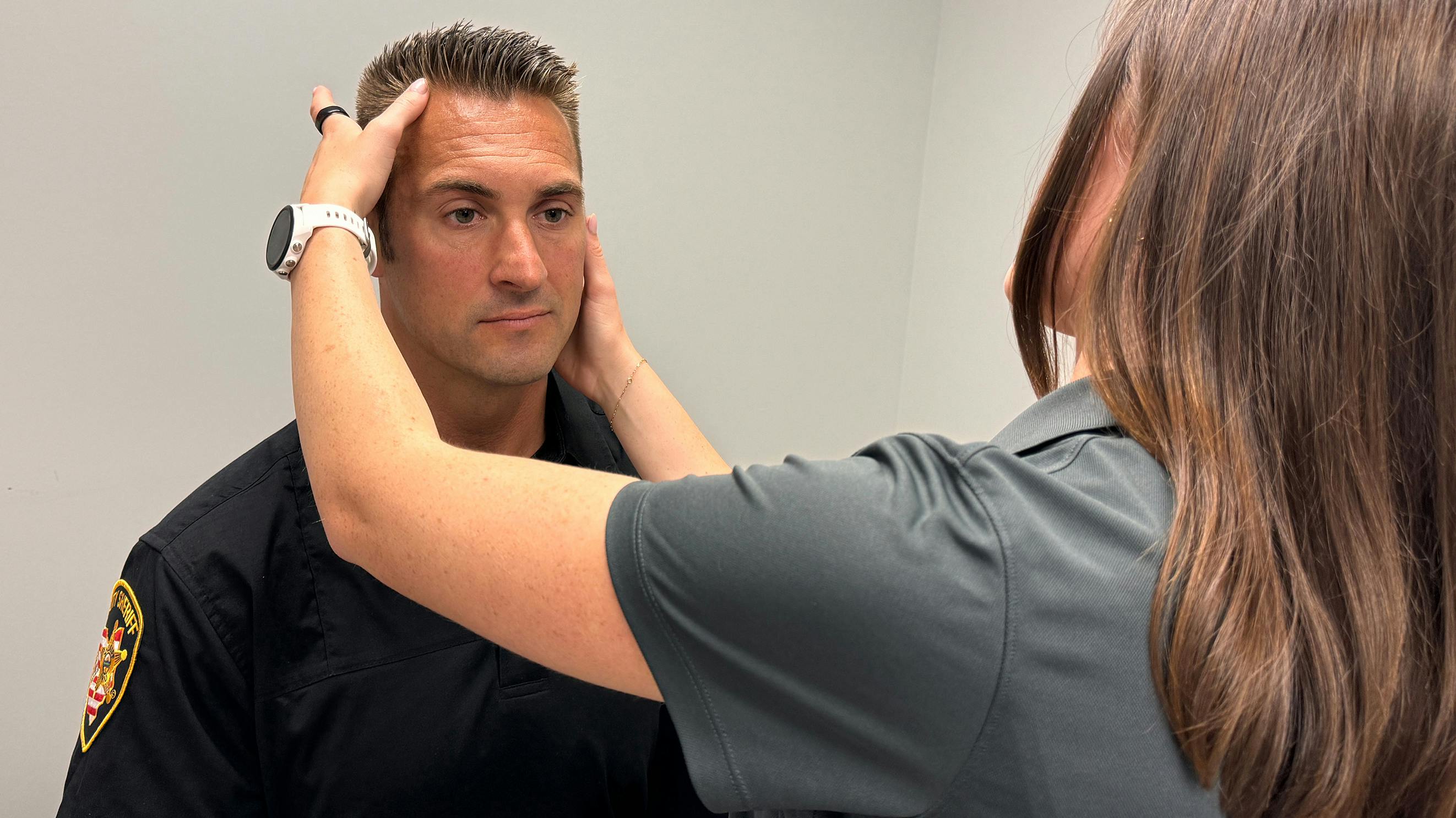 Franklin County, OH, Sheriff's Deputy Josh Walters is examined by certified athletic trainer Kate Brubaker at the Ohio State University Wexner Medical Center. A recent study by researchers at Ohio State finds law enforcement officers who have had one or more head injuries were more likely to experience symptoms of depression and PTSD.