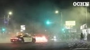 Crowd shatters rear window of LAPD vehicle after police arrive at street takeover