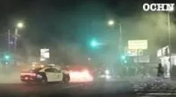 Crowd shatters rear window of LAPD vehicle after police arrive at street takeover
