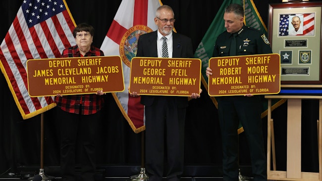 Seminole County, FL, Sheriff Dennis Lenma (right) unveils plaques honoring three fallen deputies. Pictured are Kay Williams (left), great-niece of fallen Deputy James Cleveland Jacobs, and George Pfeil Jr., son of fallen Deputy George Pfeil Sr.