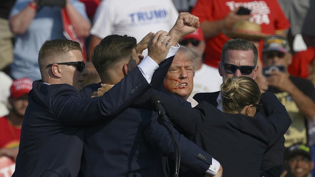 Secret Service agents surround Republican presidential candidate former President Donald Trump onstage after he was injured at a rally on July 13, 2024, in Butler, Pennsylvania.