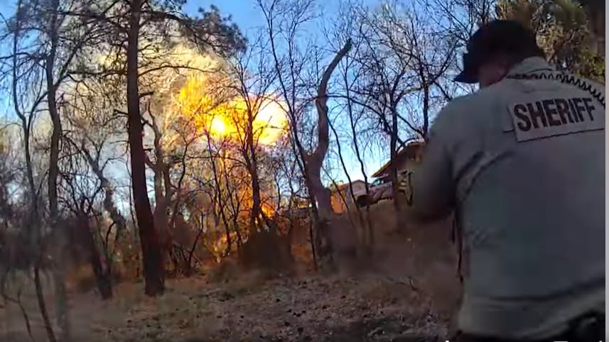 A Yavapai County, AZ, sheriff&rsquo;s deputy watches flames stretch into the sky after a fleeing suspect used a blowtorch to ignite a propane tank during a high-speed chase in Prescott on Wednesday.