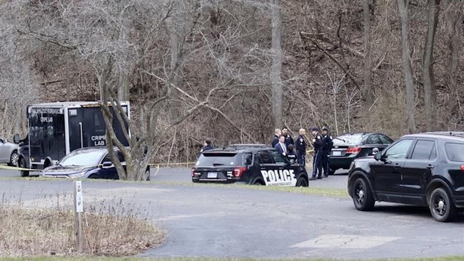 Authorities respond to a shooting Thursday near the Kalamazoo, MI, Public Schools Administration Building that wounded a Kalamazoo Township police officer and a 'wanted subject.'