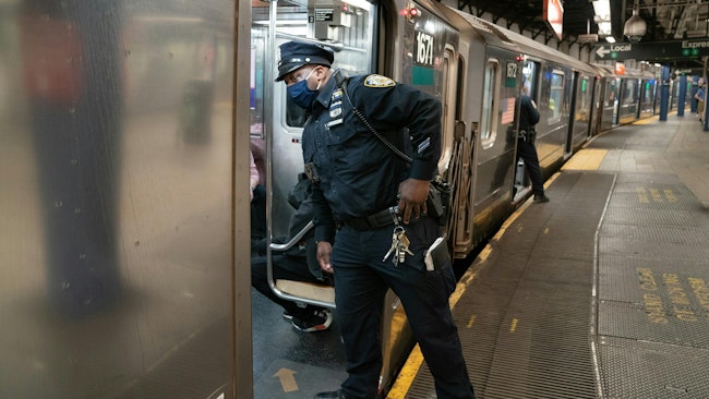 An NYPD officer checks a subway train as it pulls into the Union Square subway station in Manhattan.