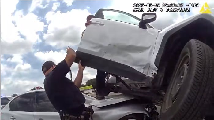 Tampa, FL, police cut through airbags to pull out a father and his 7-year-old son trapped in an SUV after the vehicle was in a May 19 rollover crash that landed half of it on a smaller car.