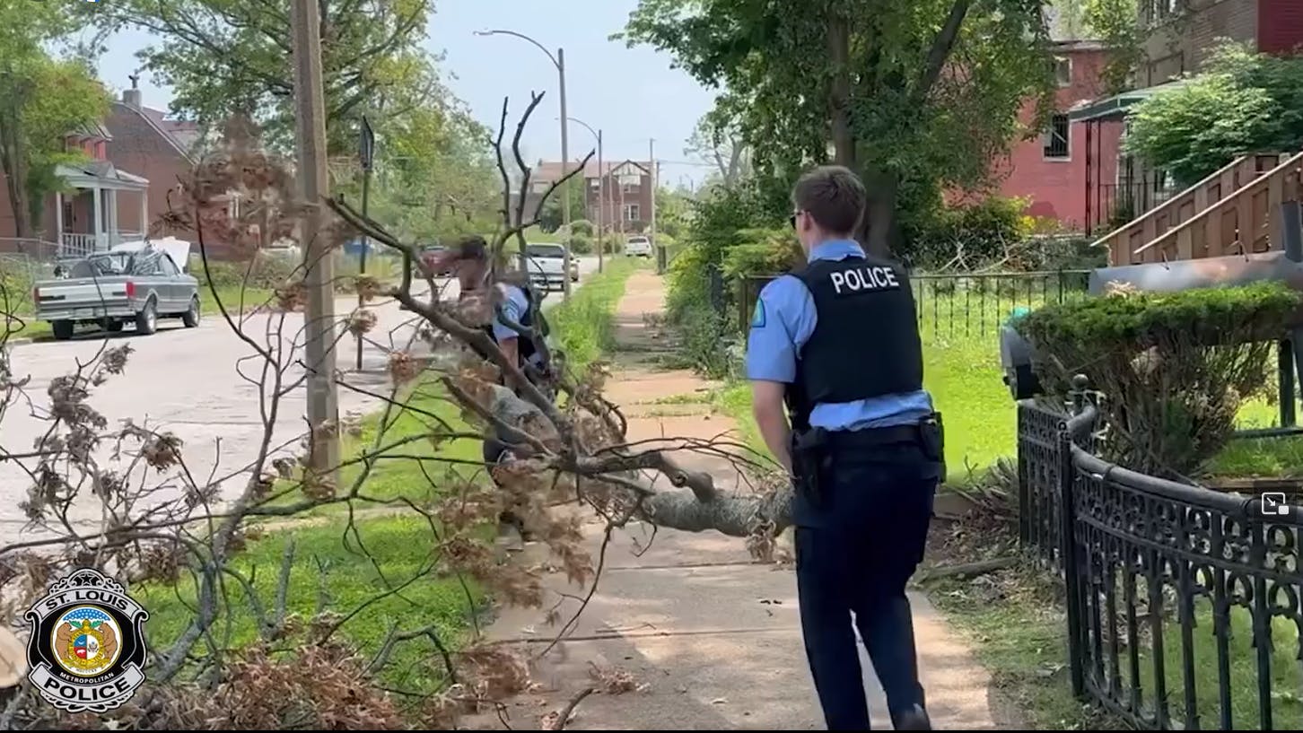 St. Louis police officers dig through rubble and debris to help trap residents after a deadly tornado ripped through the city May 16, killing five people.