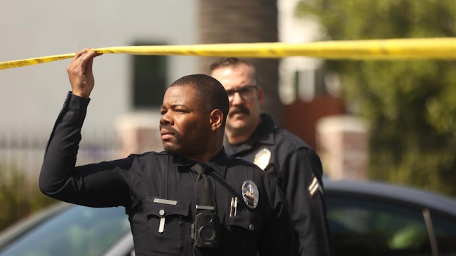 LAPD officers work at the scene of a double homicide shooting in Exposition Park in 2024.