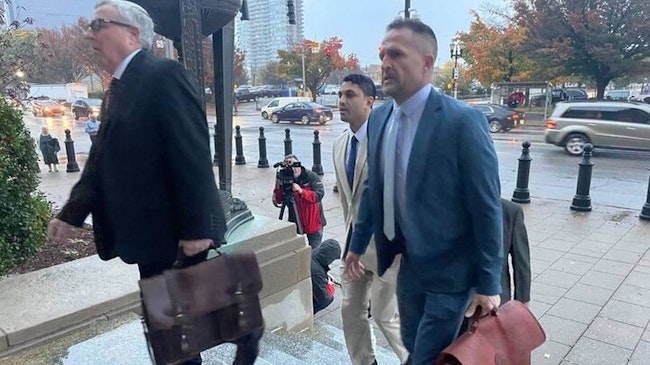 Brett Hankison (right), 47, arrives in court on alongside his attorneys for the beginning of his federal trial which will determine if he violated the civil rights of Breonna Taylor, her boyfriend, and neighbors.