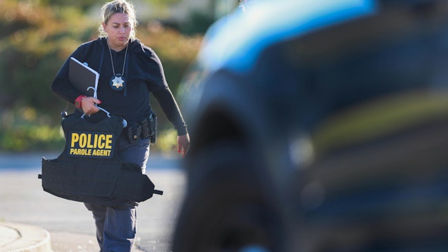 A state parole agent walks back to her car after fellow California State parole agent Joshua Lemont Byrd was fatally shot at the State of California parole office building in Oakland, Callif., on Thursday, July 17, 2025.