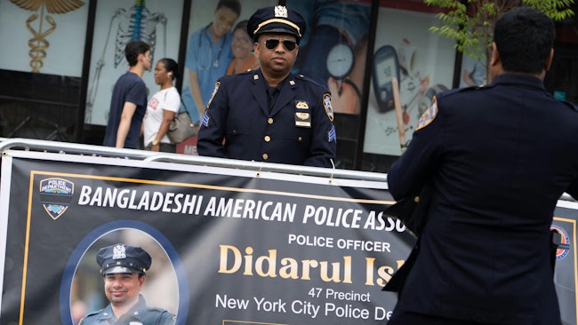 A member of the NYPD stands behind a sign at the funeral of NYPD Officer Didarul Islam in the Bronx on Thursday.