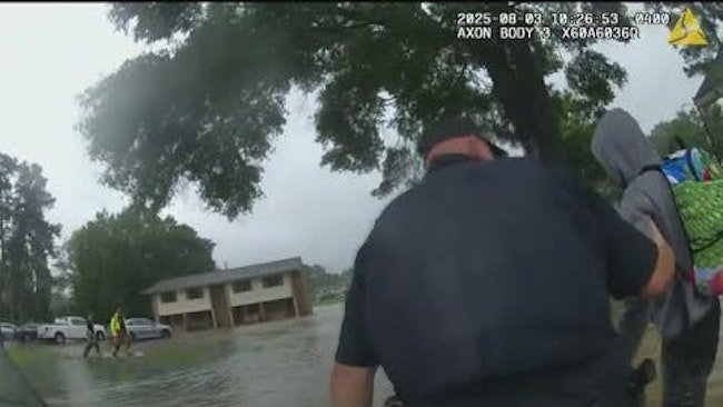 A Lake Overflowing Its Banks During A Rainstorm Had Covington Police Officers And Firefighters Wading Through Rising Floodwaters To Help Evacuate Apartment Residents, Carrying Some Individuals To Safety
