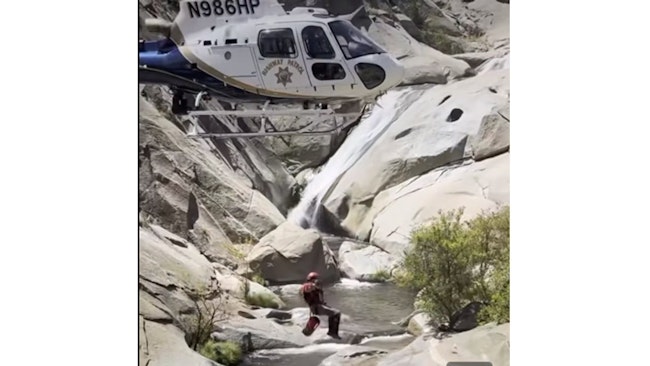 A Tulare County, CA, sheriff's deputy is lowered from a California Highway Patrol helicopter Tuesday to rescue a 46-year-old man who had been trapped behind a waterfall in Sequoia National Forest for two days.