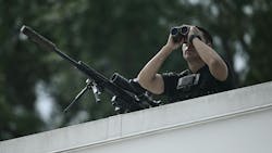 A member of the Secret Service's counter sniper team looks out from the roof of the West Wing of the White House. A member of the Secret Service's counter sniper team looks out from the roof of the West Wing of the White House.