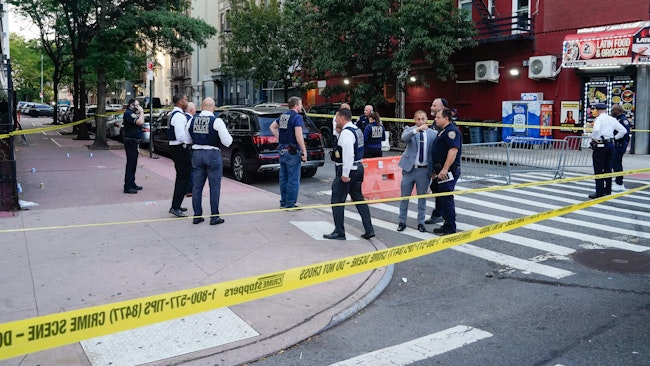 One teen was shot in the knee, and another was struck in the leg during an exchange of gunfire outside an NYPD station in Harlem, with officers opening fire before chasing after suspects on foot.
