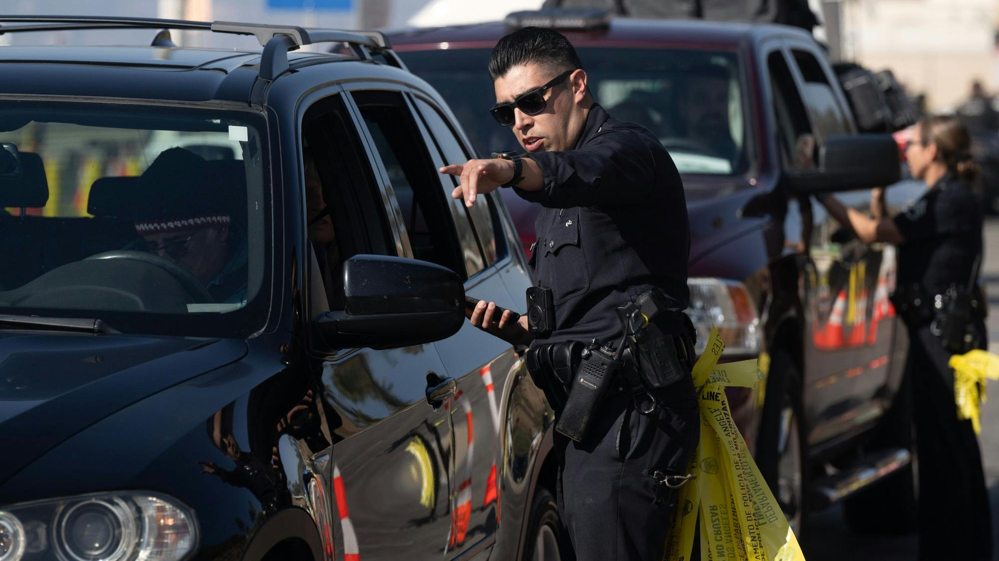 LAPD Officer Anthony Lopez checks for proof of residency before allowing vehicles into the Palisades fire burned zone in Santa Monica on Jan. 20.
