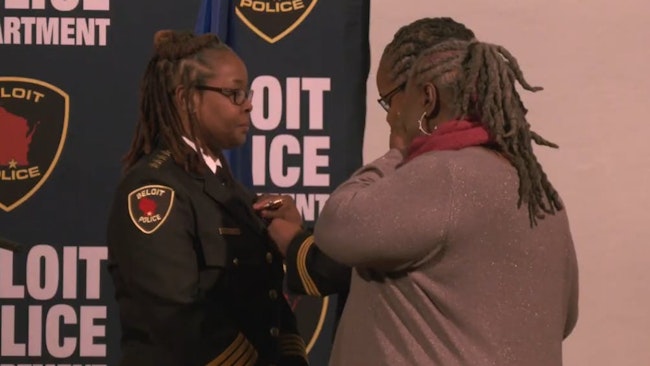 New Beloit, WI, Police Chief Schonella Stewart receives her badge from her twin sister, who also is a police chief.