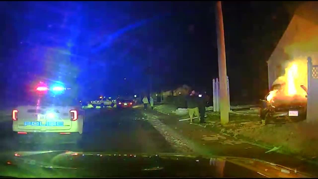 Grand Island, NE, police rush to save an unconscious driver trapped inside a burning car.