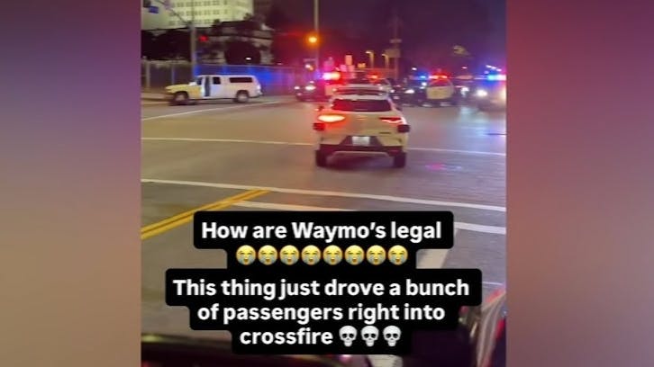 A Waymo self-driving tax travels into the scene of an LAPD high-risk felony arrest Monday.