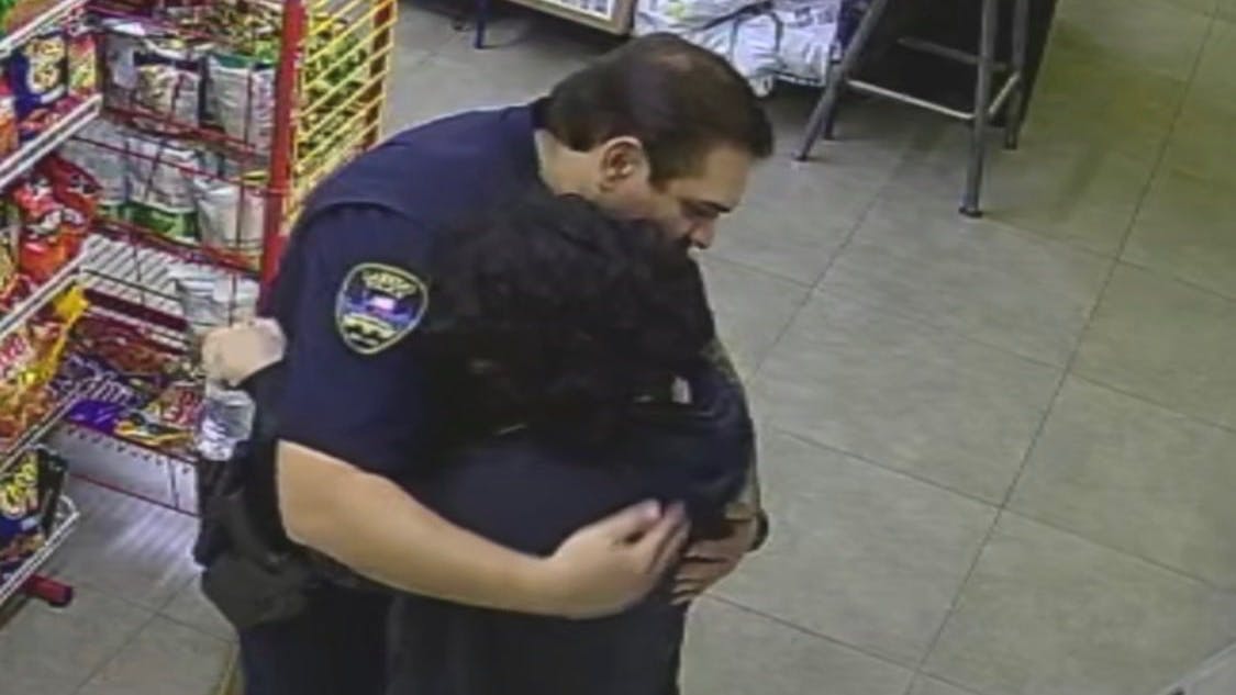 A store security camera captures an emotional moment between a Laredo, TX, police officer and a girl.