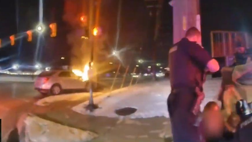 Sterling Heights, MI, police and bystanders rescue driver trapped in burning car.