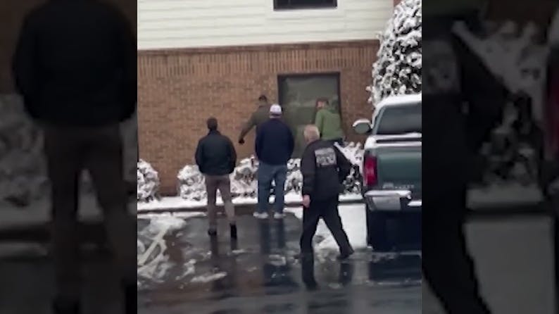 Police search a hotel for the suspected gunman in a shooting at Brown University.