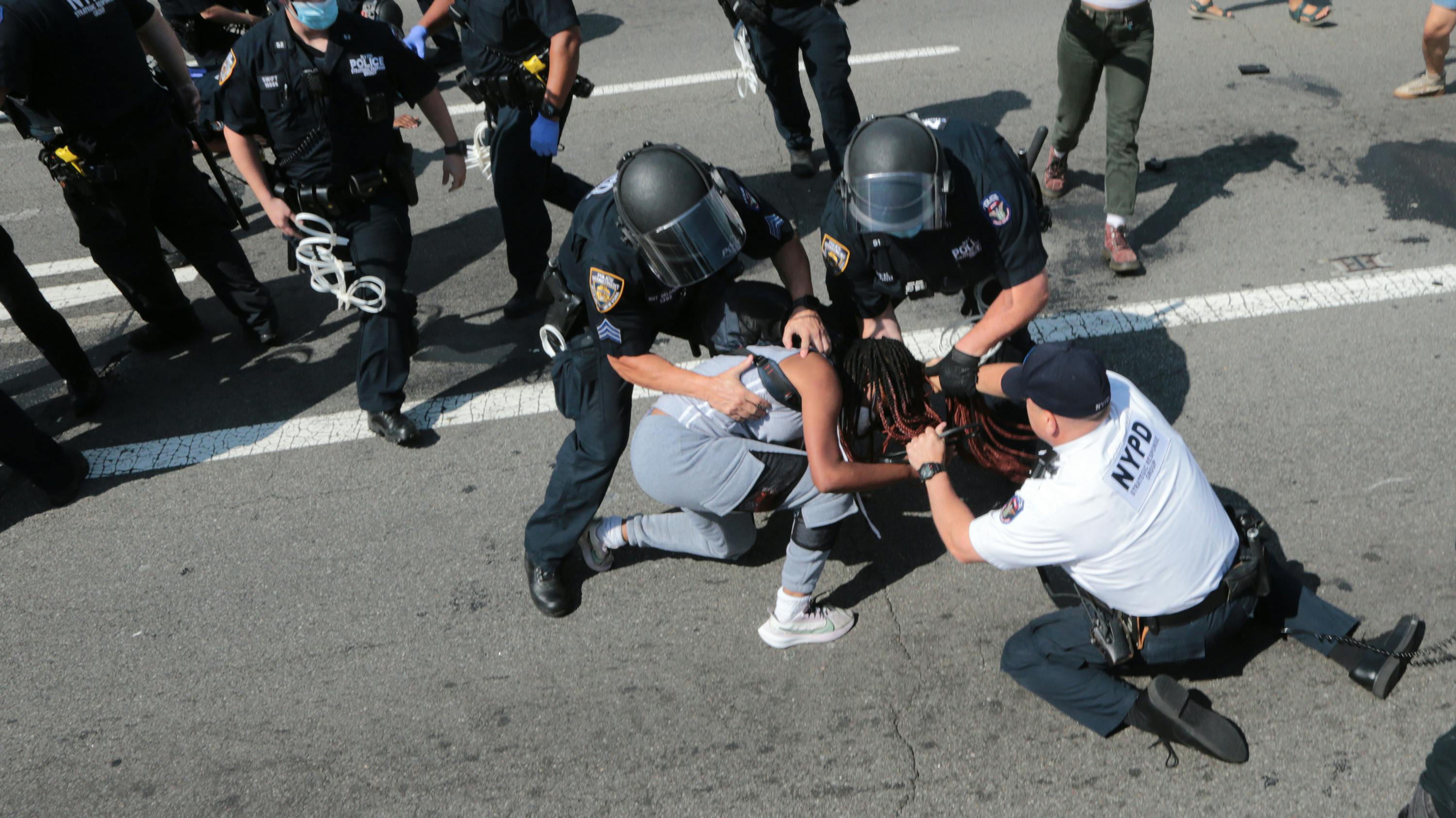 NYPD officers arrest protesters on the Brooklyn Bridge roadway during a July 2020 protest..