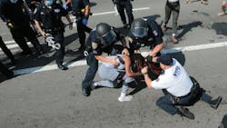 NYPD officers arrest protesters on the Brooklyn Bridge roadway during a July 2020 protest.. NYPD officers arrest protesters on the Brooklyn Bridge roadway during a July 2020 protest..