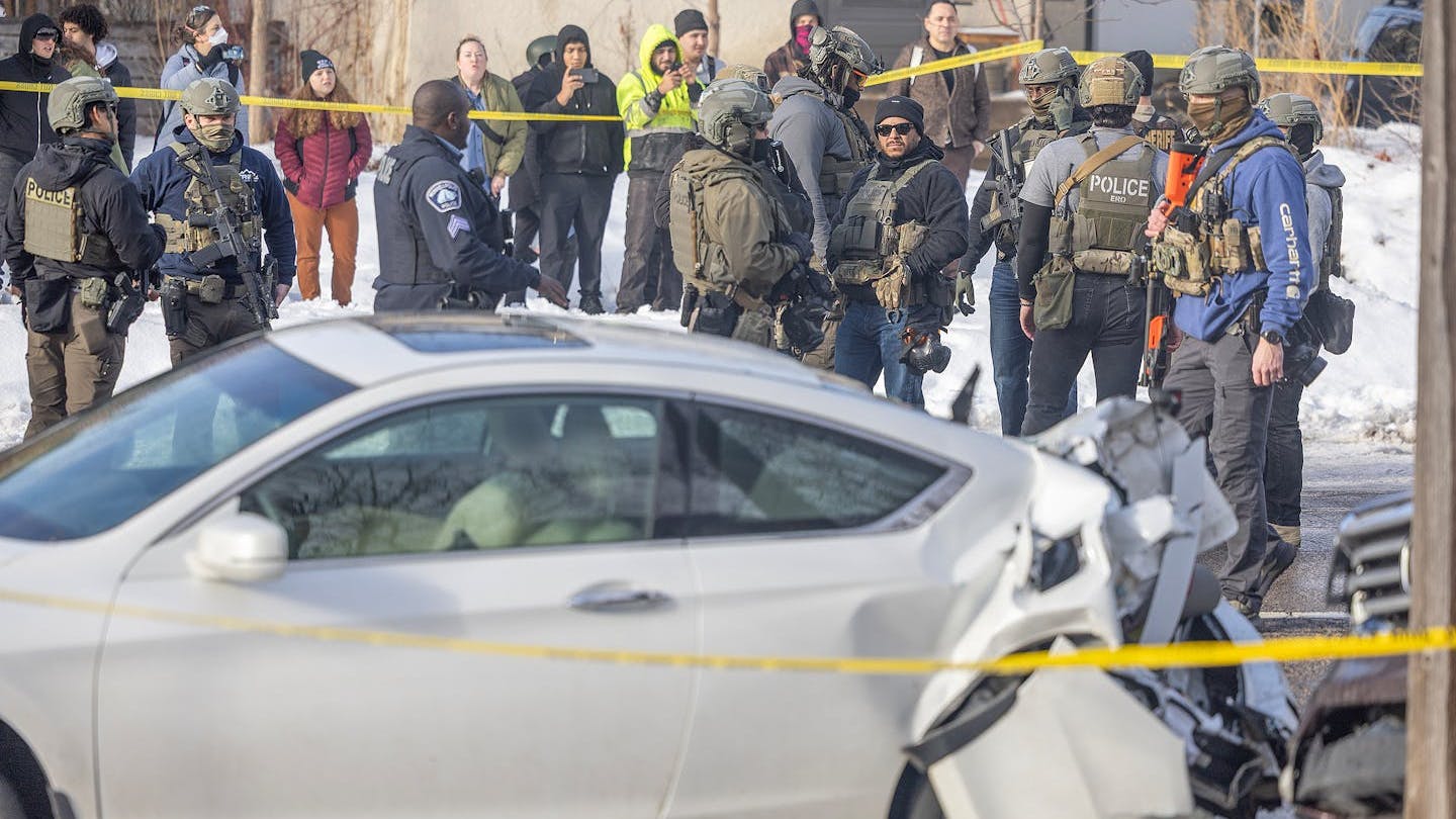 Law enforcement agents stand at the scene of a shooting near E 34th Street and Portland Avenue in Minneapolis on Jan. 7.