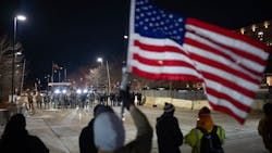 Demonstrators wave flags and chant from across the street while federal agents stand in front of an entrance to the Whipple Federal Building at Fort Snelling on Jan. 11. Demonstrators wave flags and chant from across the street while federal agents stand in front of an entrance to the Whipple Federal Building at Fort Snelling on Jan. 11.