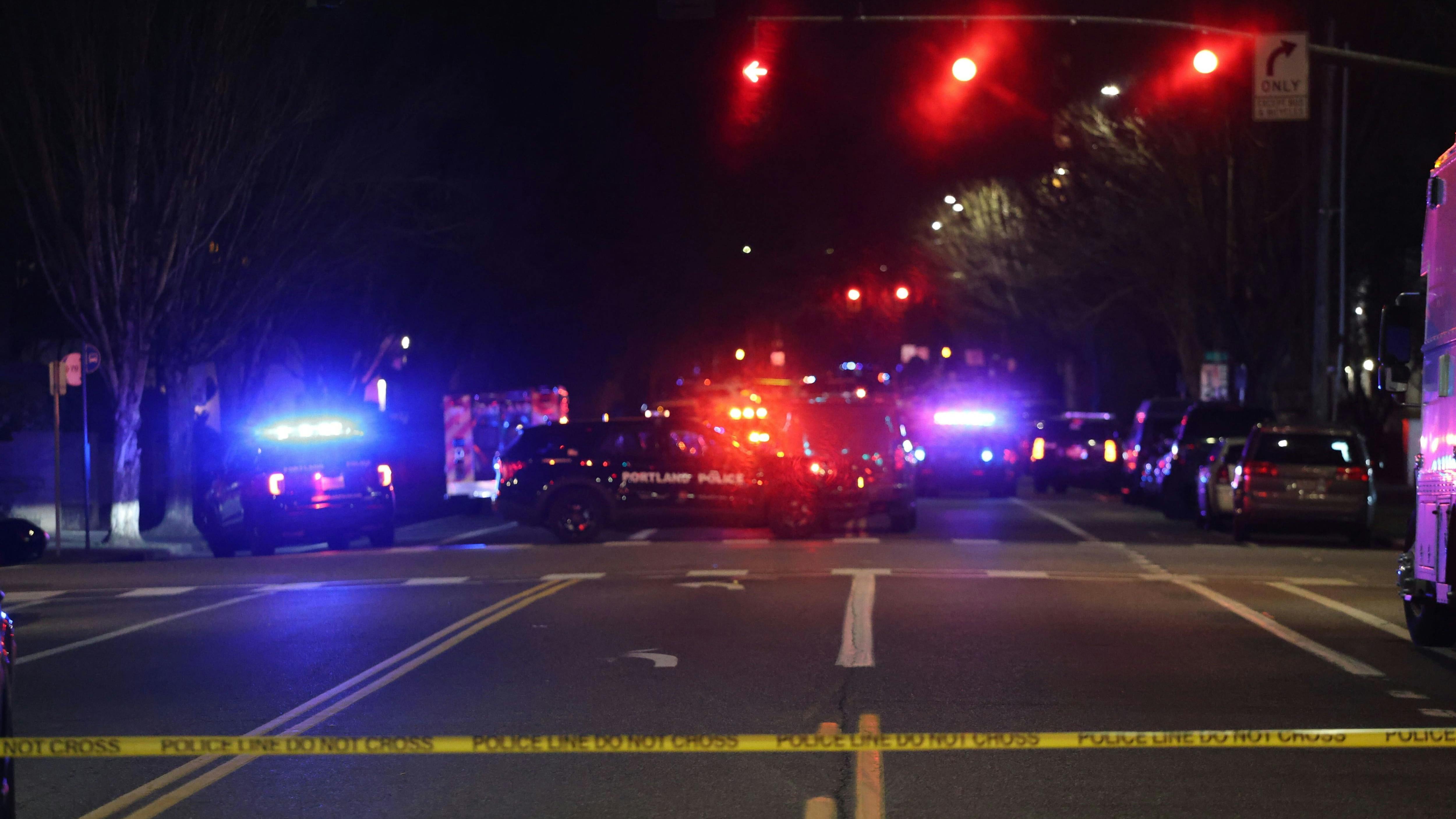 Portland police blocked streets near the Lloyd Center in Northeast Portland late Monday as they searched for a person who opened fire on police, injuring two officers.
