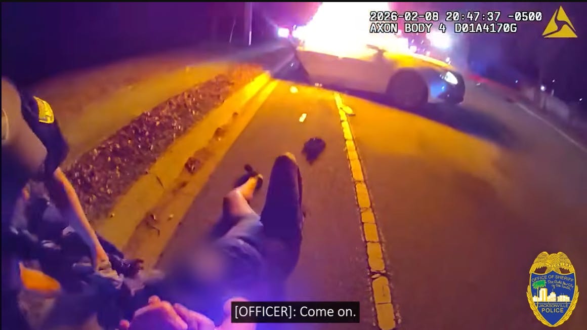 A Jacksonville, FL, sheriff's officer pulls a driver from a fiery crash.