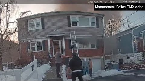 Mamaroneck, NY, police use a ladder to rescue a trapped family during a house fire.
