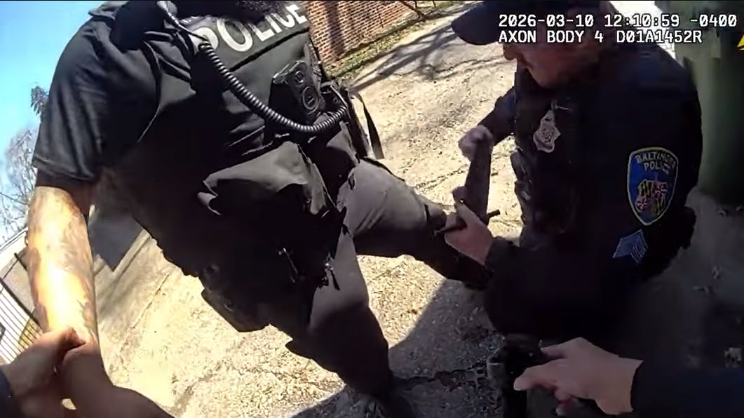 A tourniquet is applied to a wounded Baltimore police officer