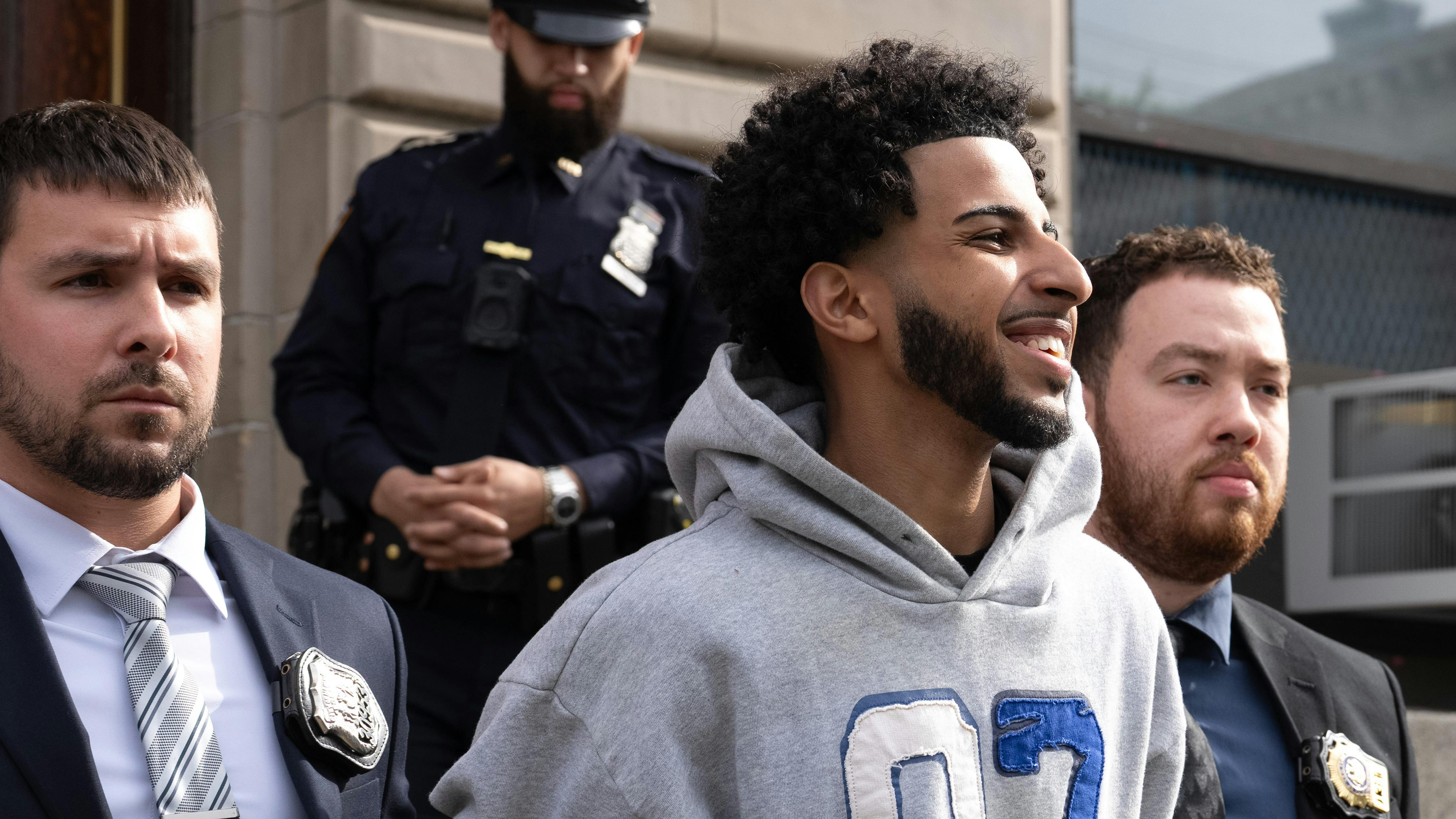 Asil Assaidi is pictured in police custody leaving the NYPD's 104th Precinct stationhouse in Queens on Thursday, April 23, 2026.