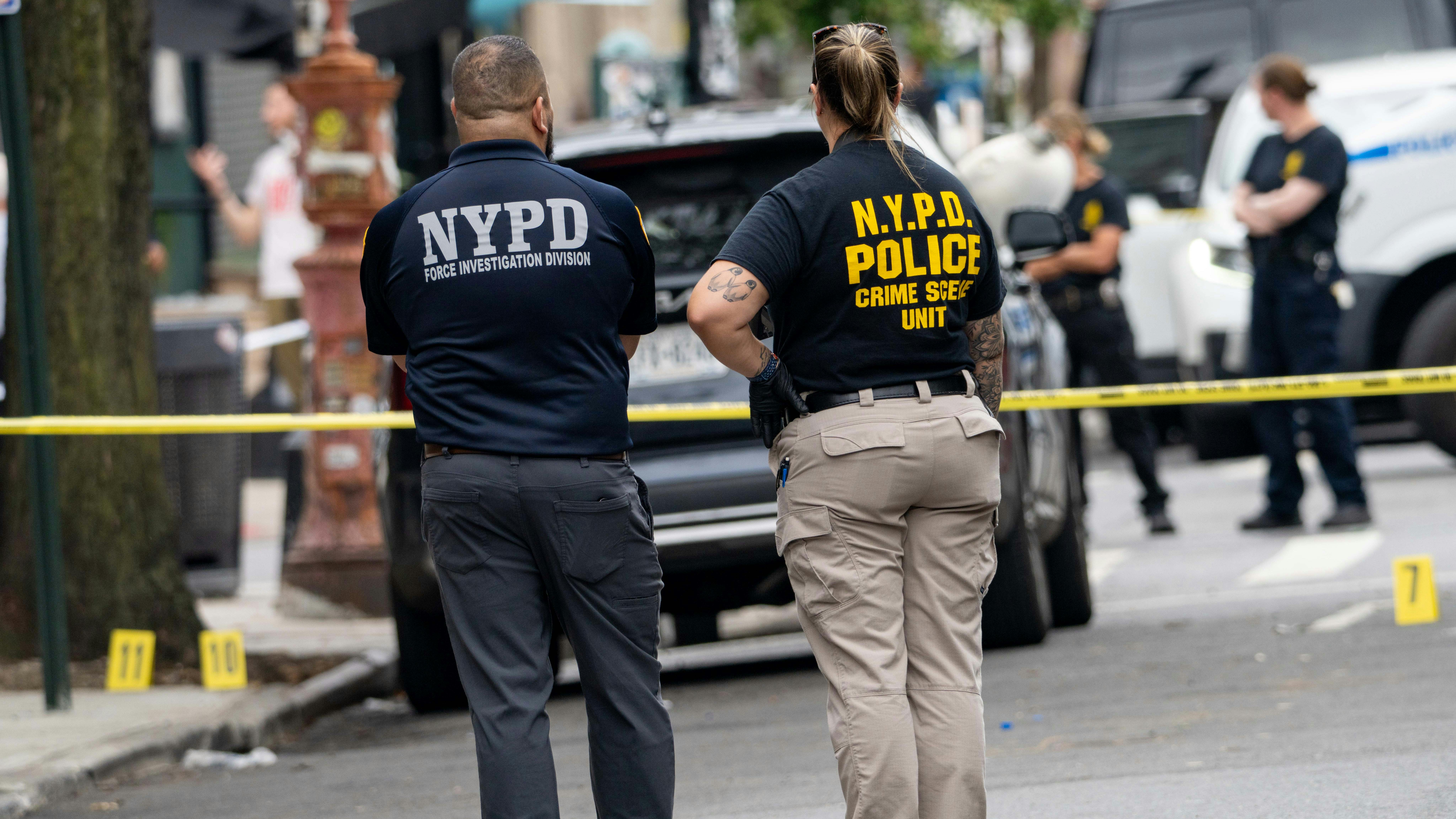 NYPD officers investigate the shooting of a fellow officer struck in the back