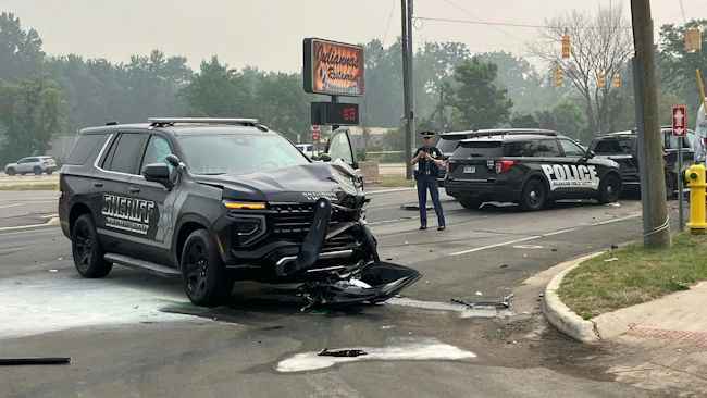 An armed suspect stole a Kalamazoo County deputy's cruiser after shooting the officer in the leg during a struggle