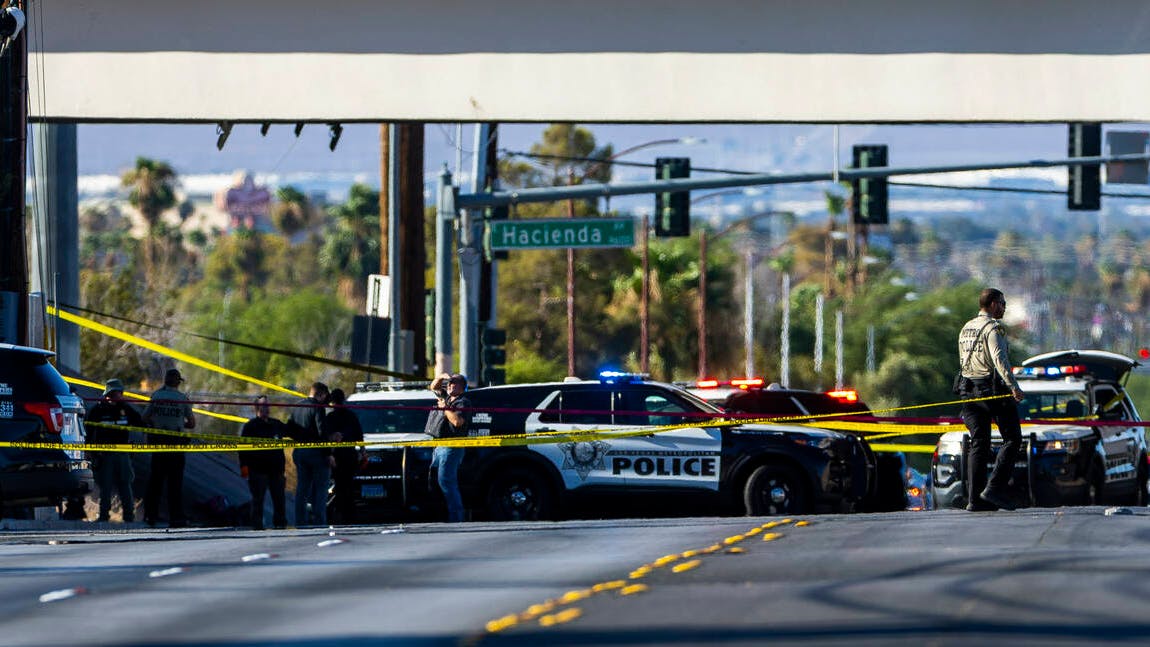 Las Vegas police officers gather along Mountain Vista Street after a fellow officer was fatally shot Tuesday. A 30-year-old officer died following a gun battle with an armed suspect nearby, Sheriff Kevin McMahill said.
