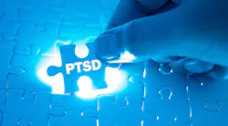 Hand holding a blue PTSD puzzle piece