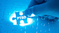 Hand holding a blue PTSD puzzle piece