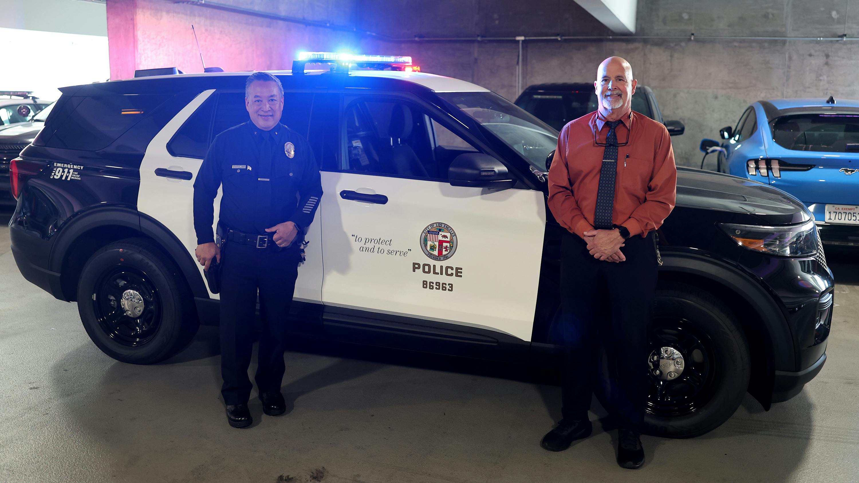 LAPD Cmdr. Blake Chow and Greg Field, director of police transportation, Motor Transport Division, with a cruiser with the new Rumbler siren system