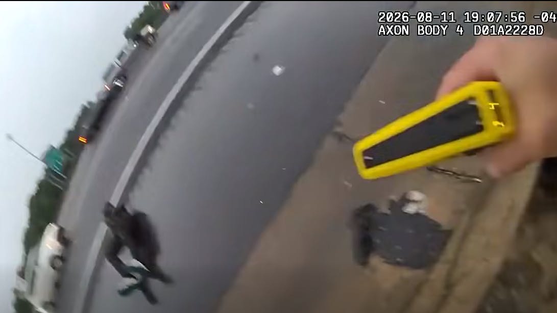 An Atlanta police officer runs across a busy interstate to apprehend a theft suspect