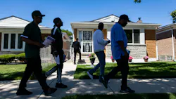 Community violence interrupters and representatives from the Chicago Police Department’s Office of Victim Services canvass a neighborhood