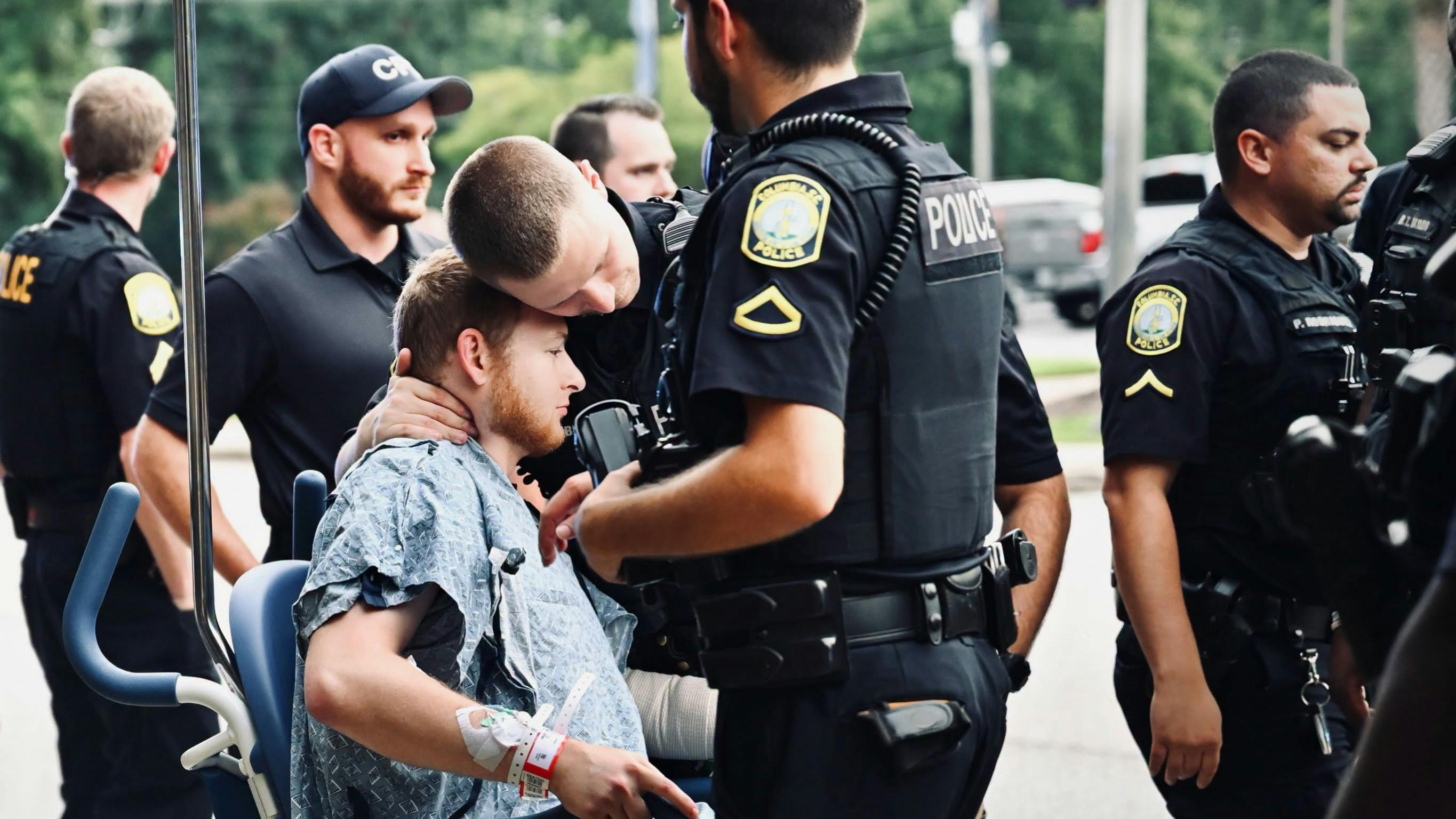 Wounded Columbia Police Officer David Dymock receives a hug from a colleague after he's released from the hospital