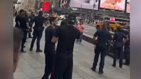 NYPD officers confront a woman armed with knives who was accused of stabbing two strangers
