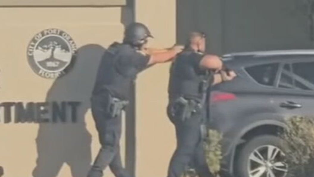 Port Orange police officers confront a woman accused of opening fire inside a station lobby