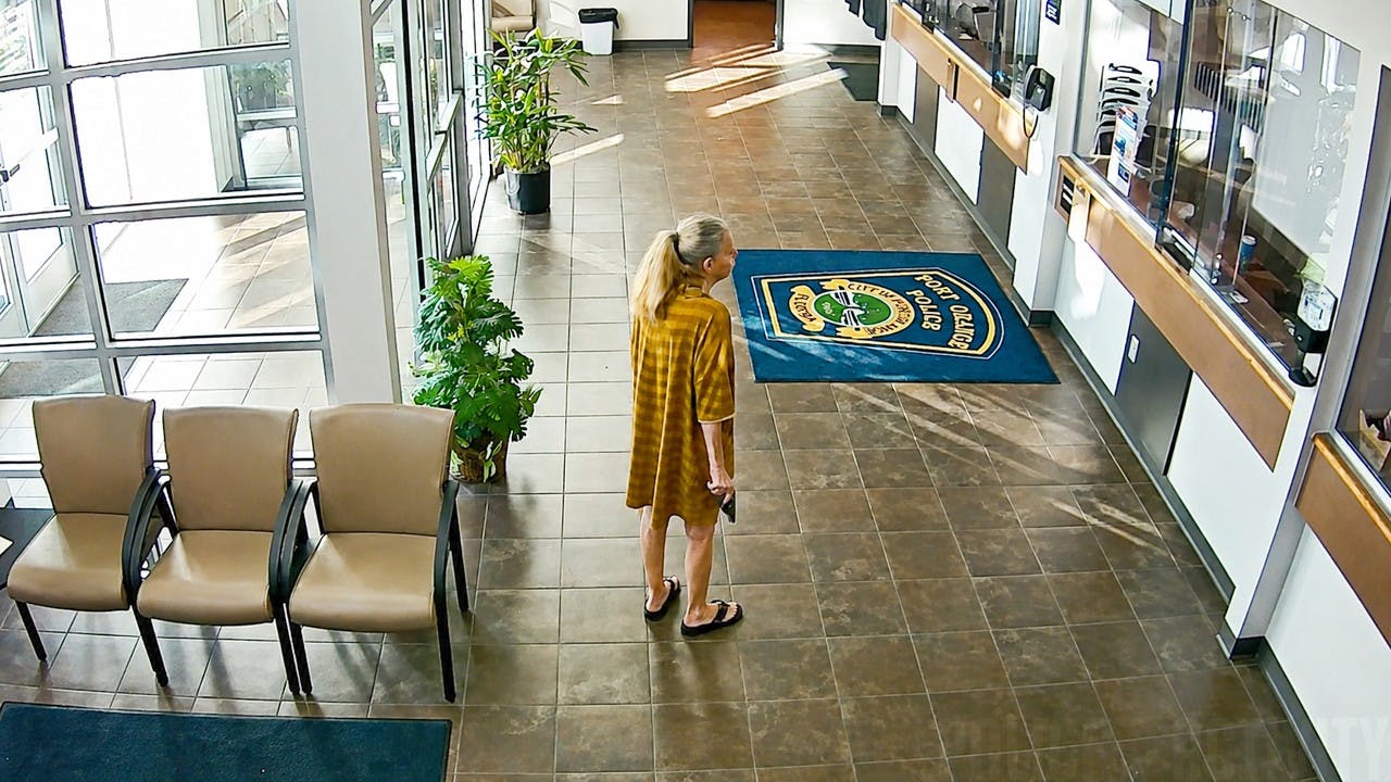 A woman with a handgun enters the lobby of a Port Orange police station