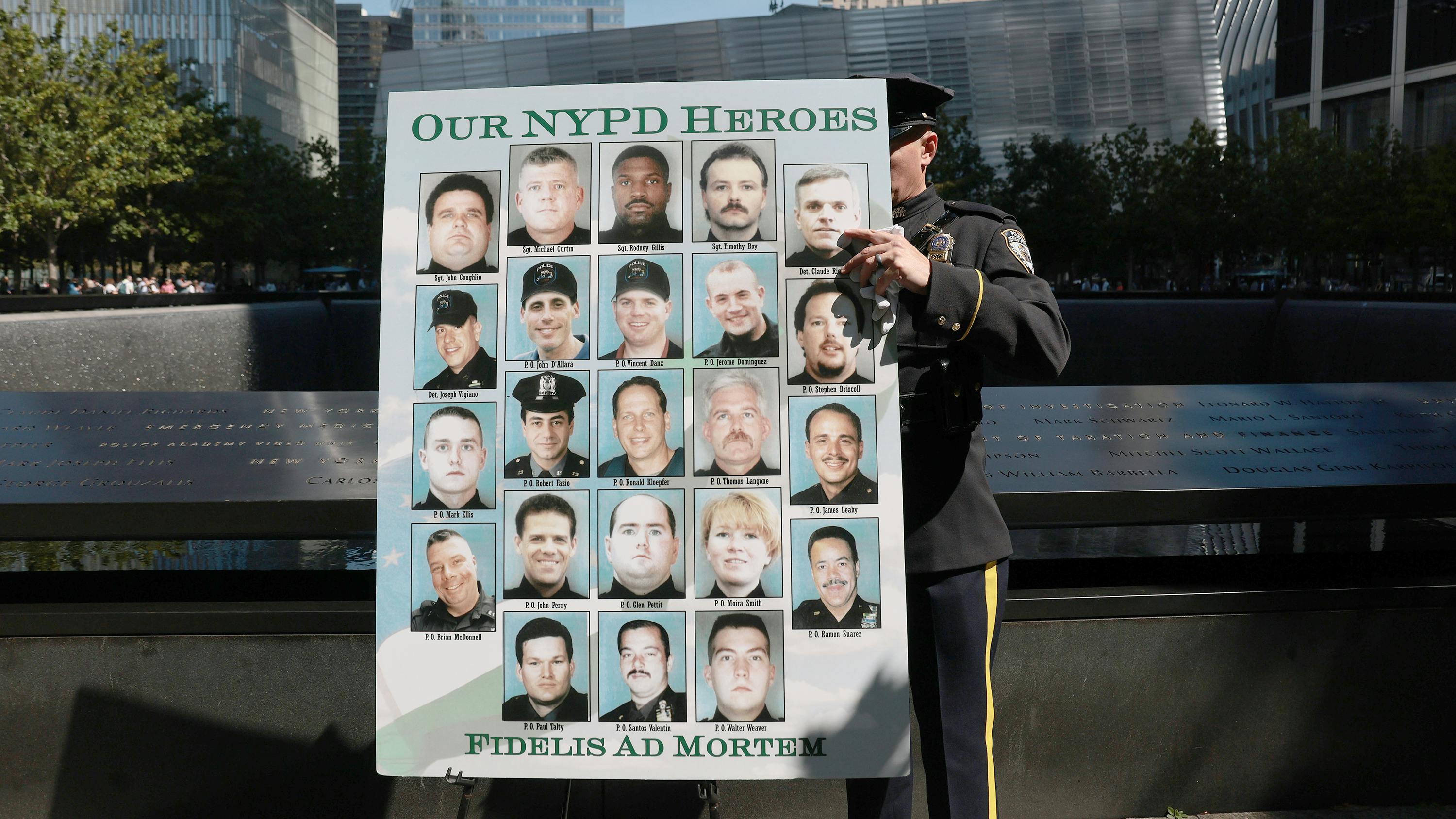 NYPD officer displays poster honoring lives of NYPD officers lost during 9/11