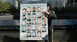 NYPD officer displays poster honoring lives of NYPD officers lost during 9/11