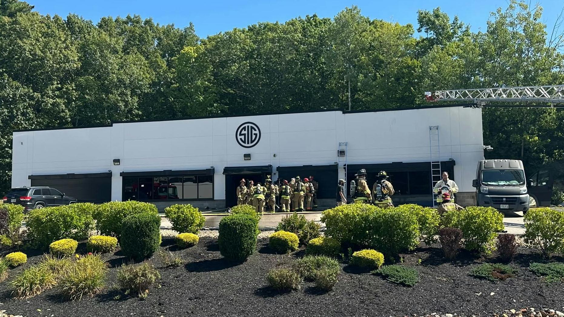 Firefighters work at the scene of three-alarm fire at the Sig Sauer facility in Epping